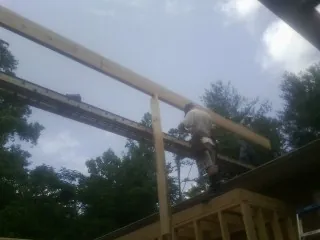 Carpenter setting a ridge beam over a new addition frame — Ice Dam Removal by Roofing Brothers in Yreka