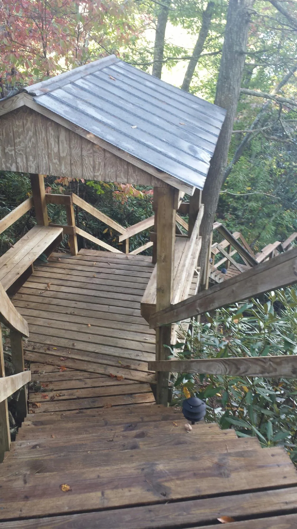 Metal roofed shelter over wooden steps on a wooded walkway — Skylight Repair & Installation work by our crew in Yreka